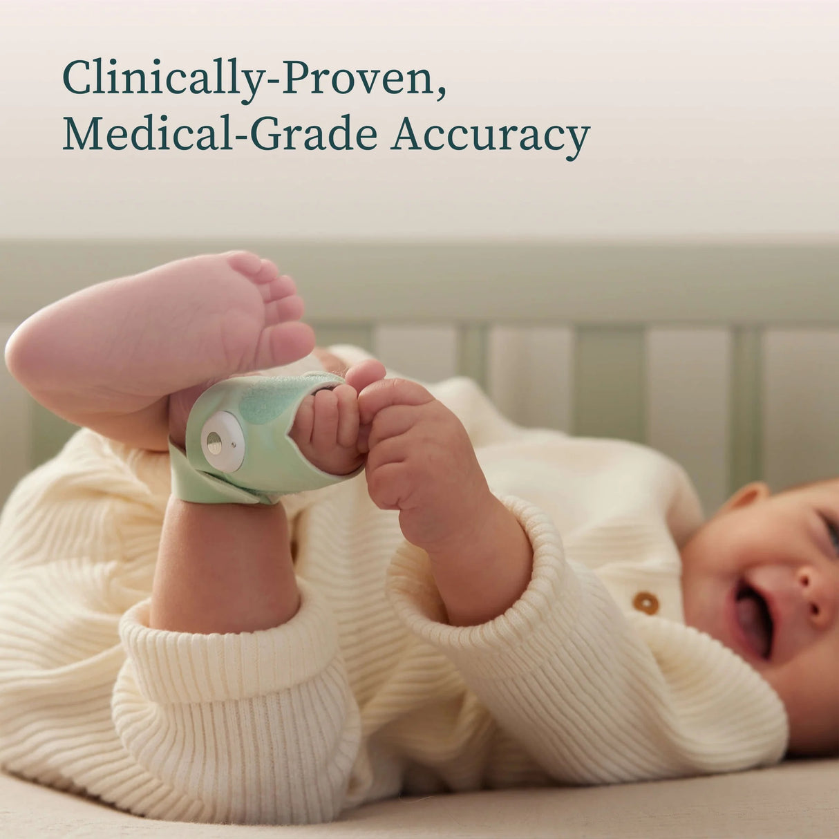 Baby lying in a crib with feet wearing green socks, 'Clinically-Proven, Medical-Grade Accuracy'.