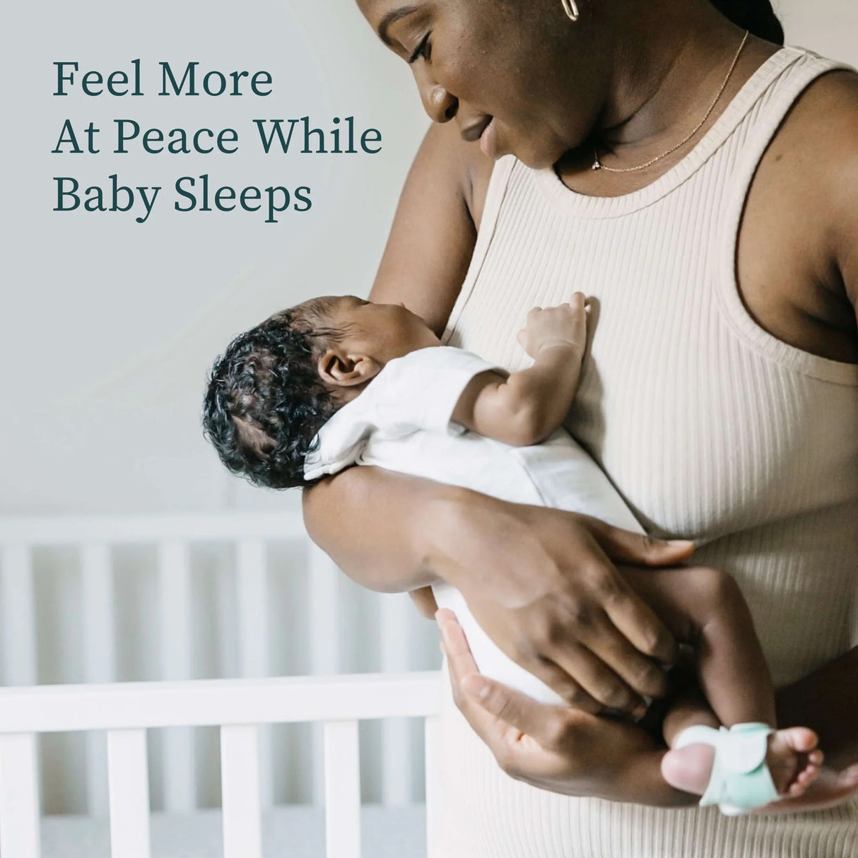 Woman holding a baby with text 'Feel More At Peace While Baby Sleeps' on a light background