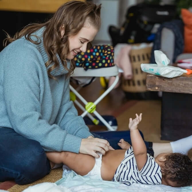 mother changing baby's nappy