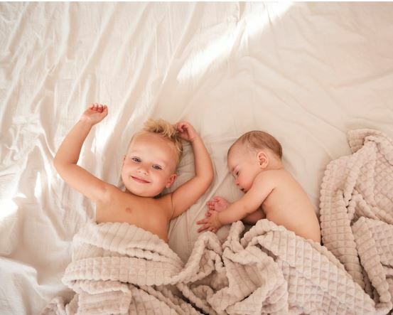 siblings laying next to each other