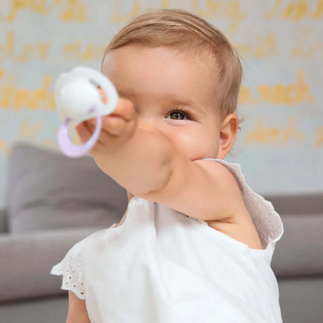 toddler holding NUK soother